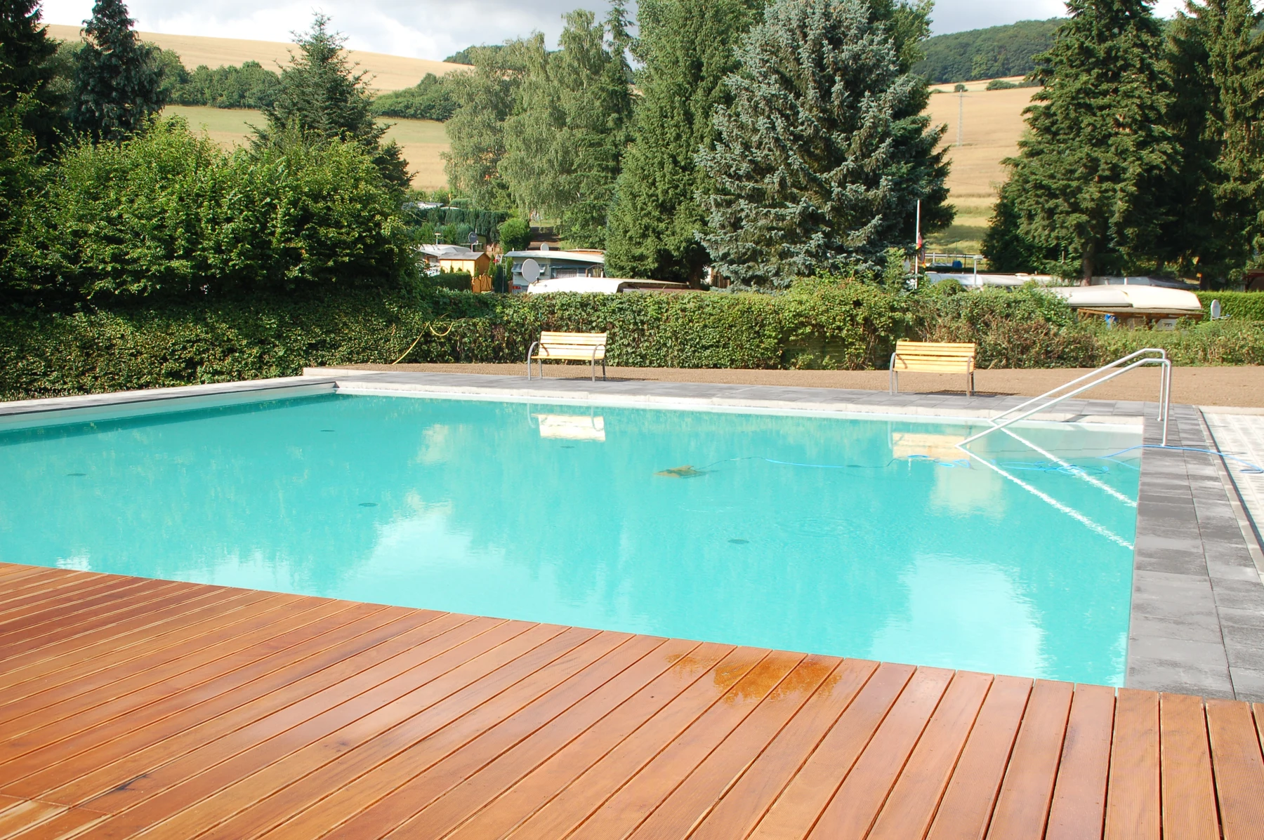 At Donnersberg, an outdoor swimming pool is encircled by trees and seating areas.
