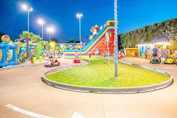 At Pra delle Torri, kids and adults drive miniature vehicles on a circuit encircled by inflatable attractions and illuminated by streetlights.