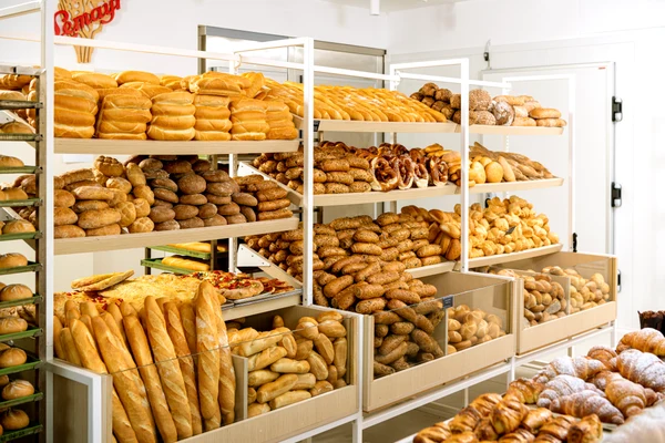At Marina di Venezia, shelves showcasing different varieties of bread and baked goods are found in a brightly lit bakery.
