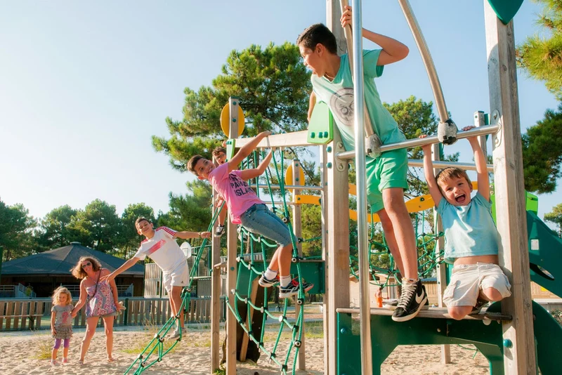 At Marvilla Parks Atlantic Club Montalivet, kids are scaling a play structure encircled by trees and sand.